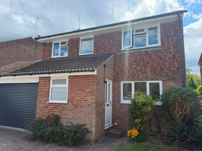 White uPVC replacement windows fitted across a detached house by Team Frames