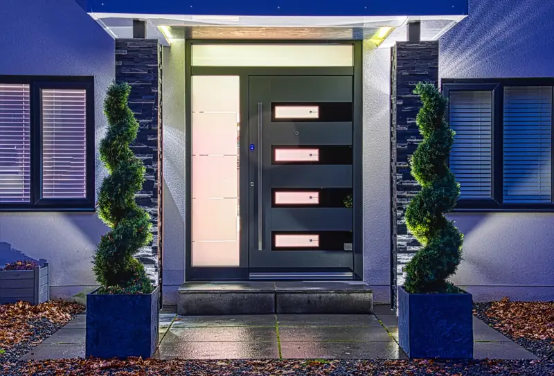 Illuminated Spitfire S500 aluminium entrance door with glazed sidelight at dusk