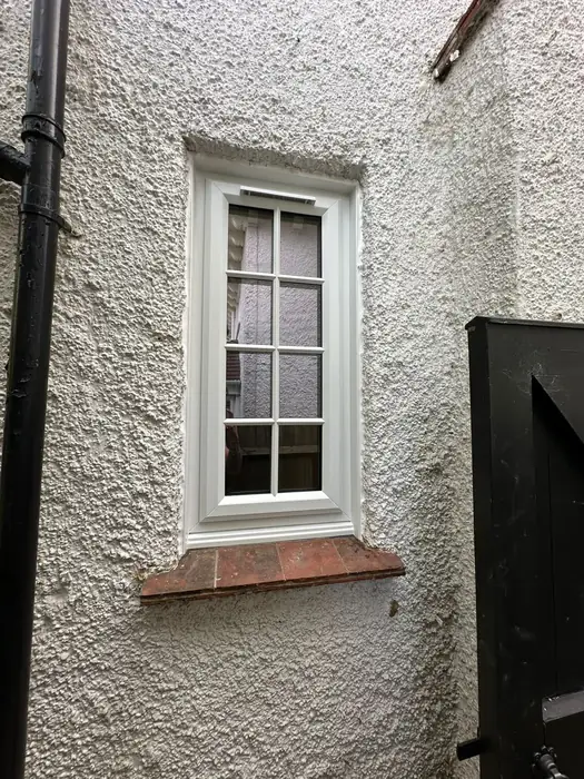 White uPVC casement window fitted to a rendered cottage by Team Frames
