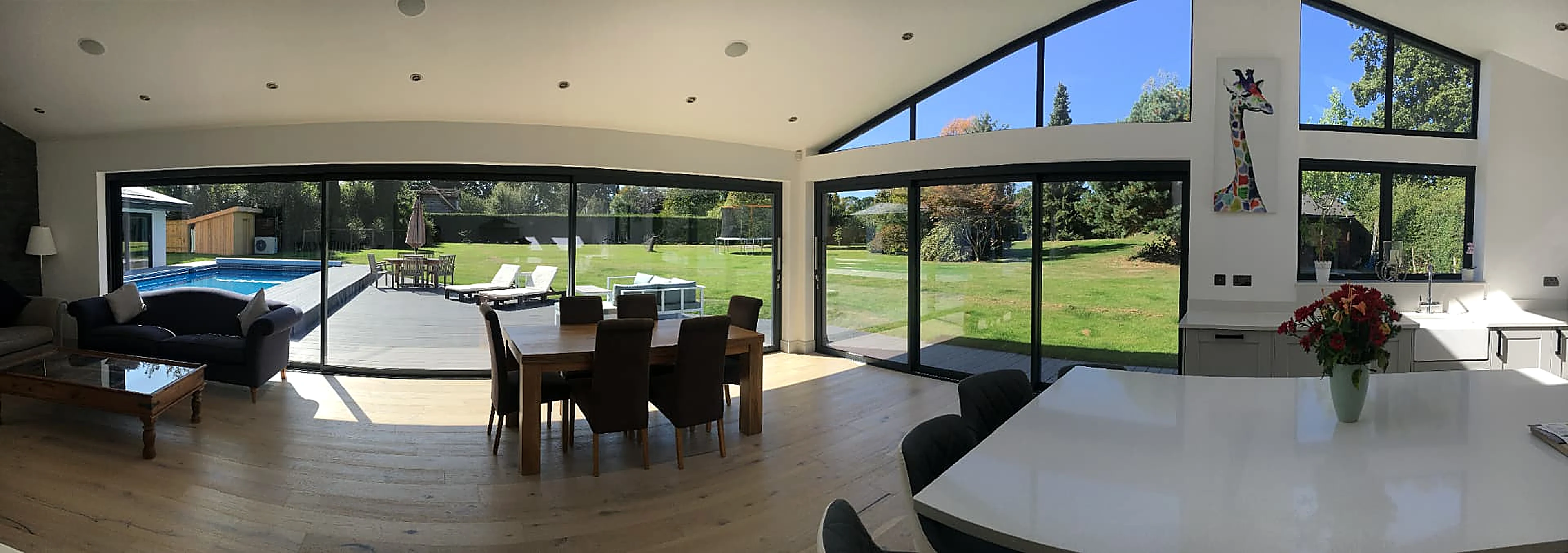 Aluminium sliding doors and gable glazing across an open-plan kitchen and living space