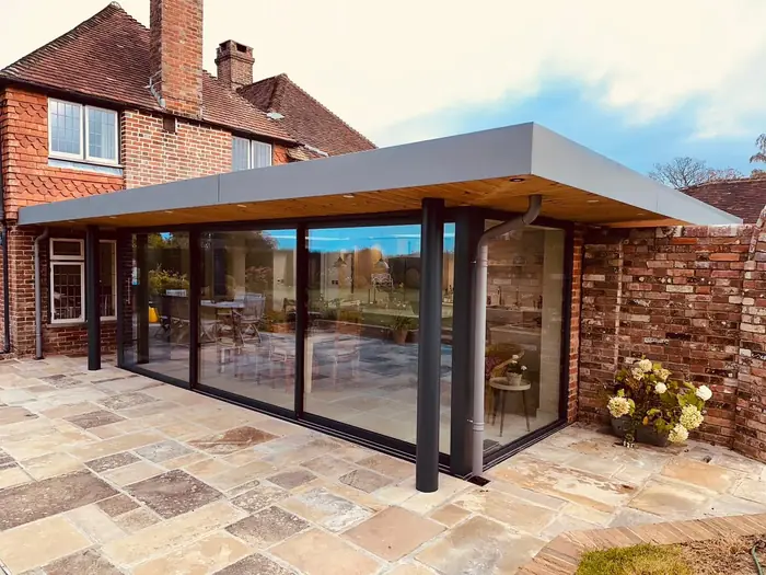 Anthracite aluminium bi-fold doors to a flat-roof garden room installed by Team Frames