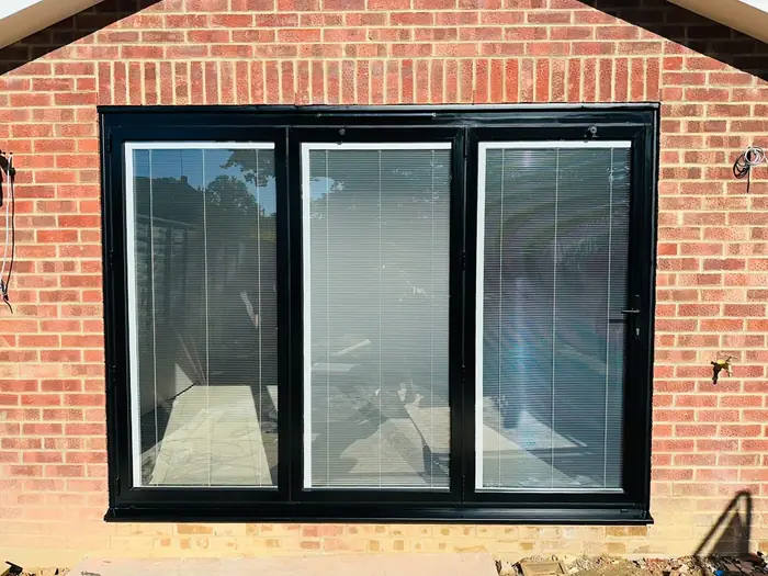 Dark aluminium bi-fold doors installed by Team Frames in Surrey