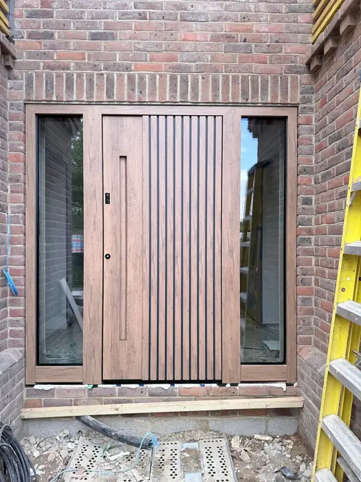 Contemporary slatted oak-effect entrance door installed by Team Frames