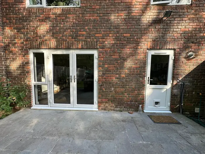White uPVC French doors with a side panel installed by Team Frames